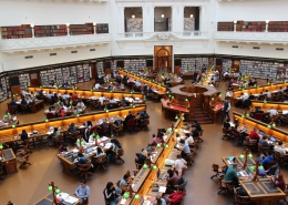 Birdseye view of library filled with people at desks reading